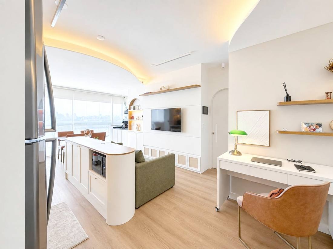 Sala integrada com cozinha, painel de madeira e iluminação indireta