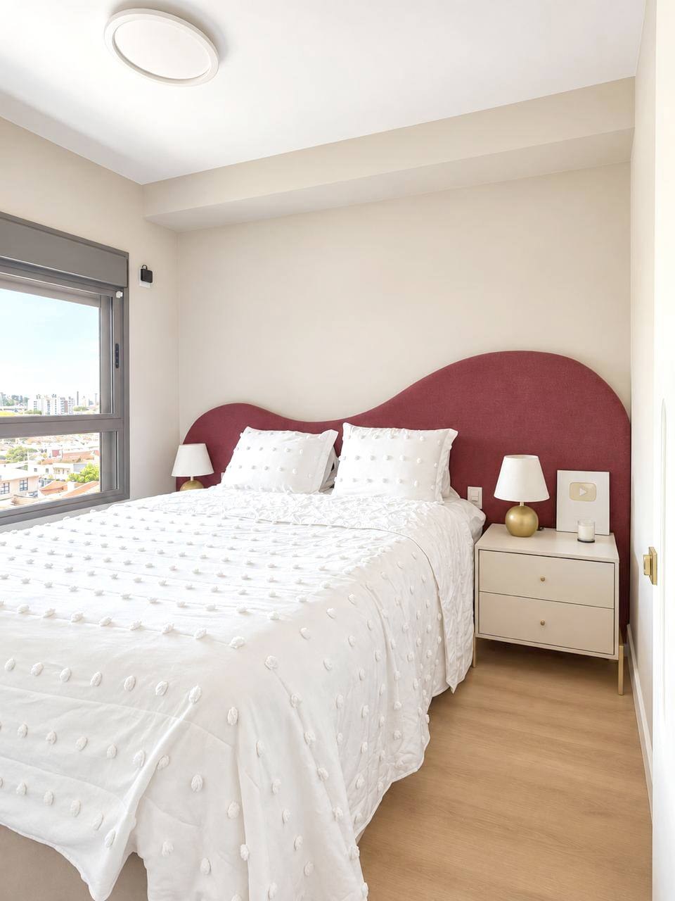 Quarto com cabeceira vinho e roupa de cama branca